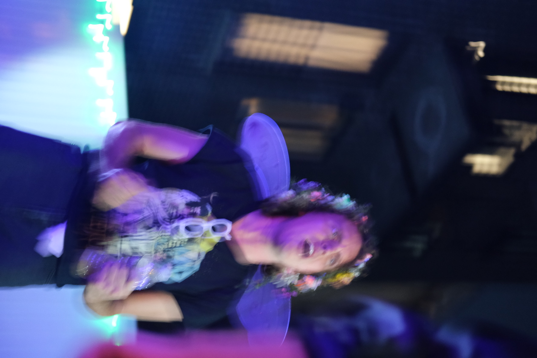 Two faerie partygoers in saturated yellow and green light