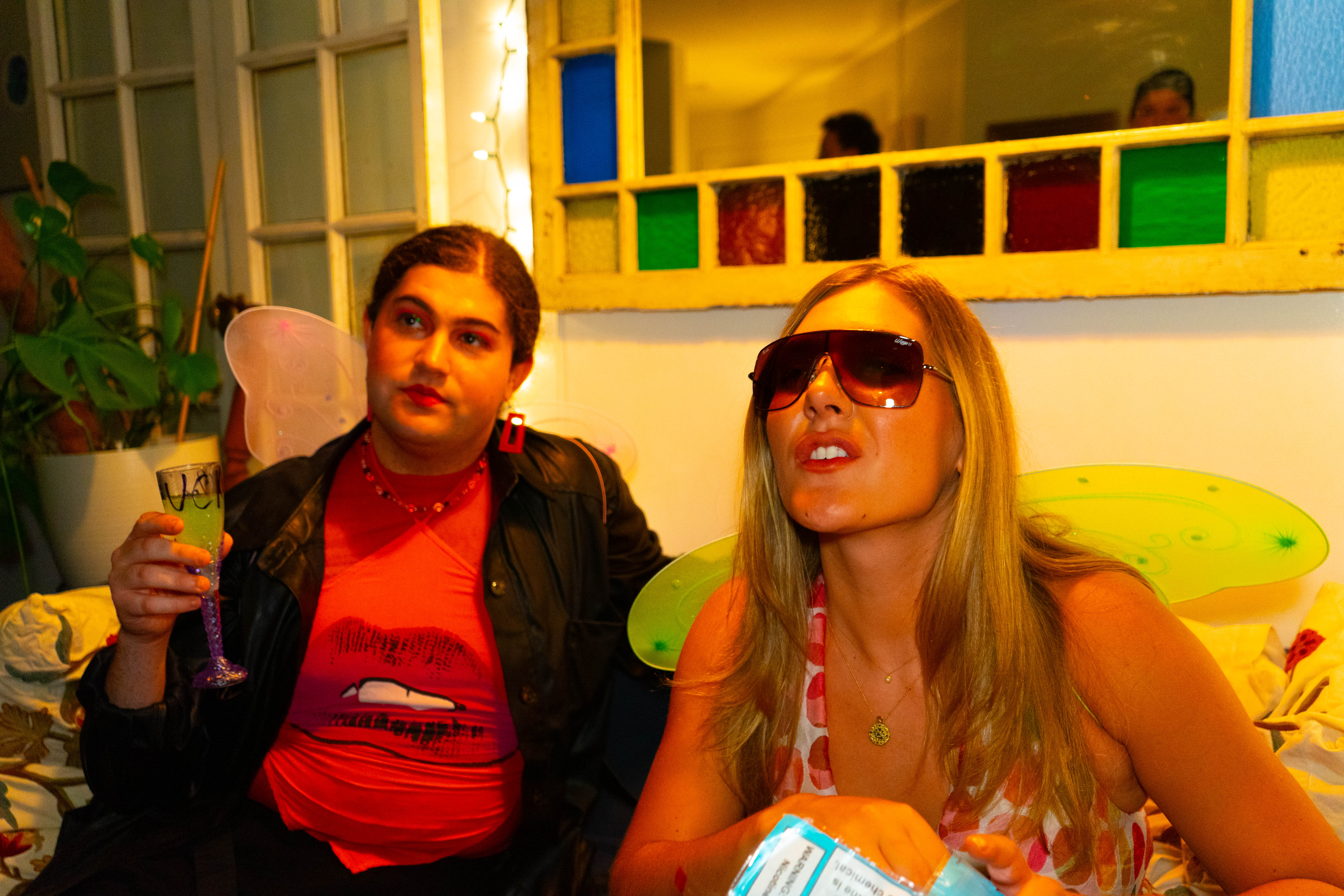 Performers gathered near a colorful window in warm light