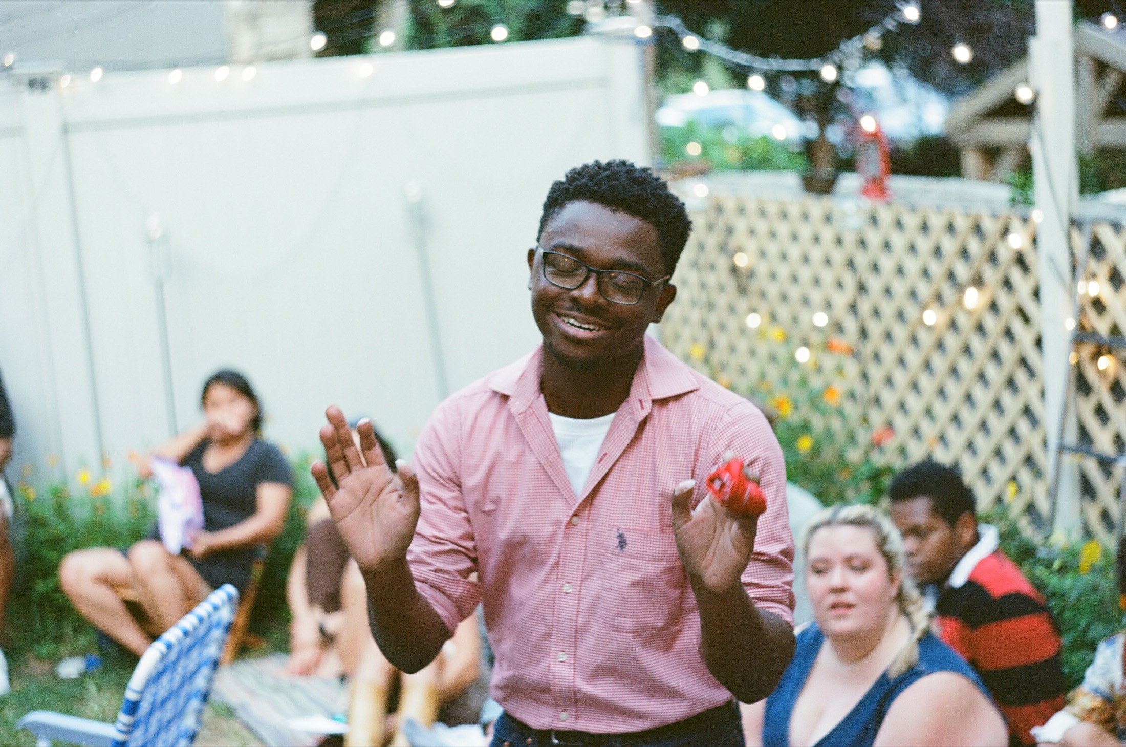 Howie Newsome smiles while speaking to the audience in a backyard