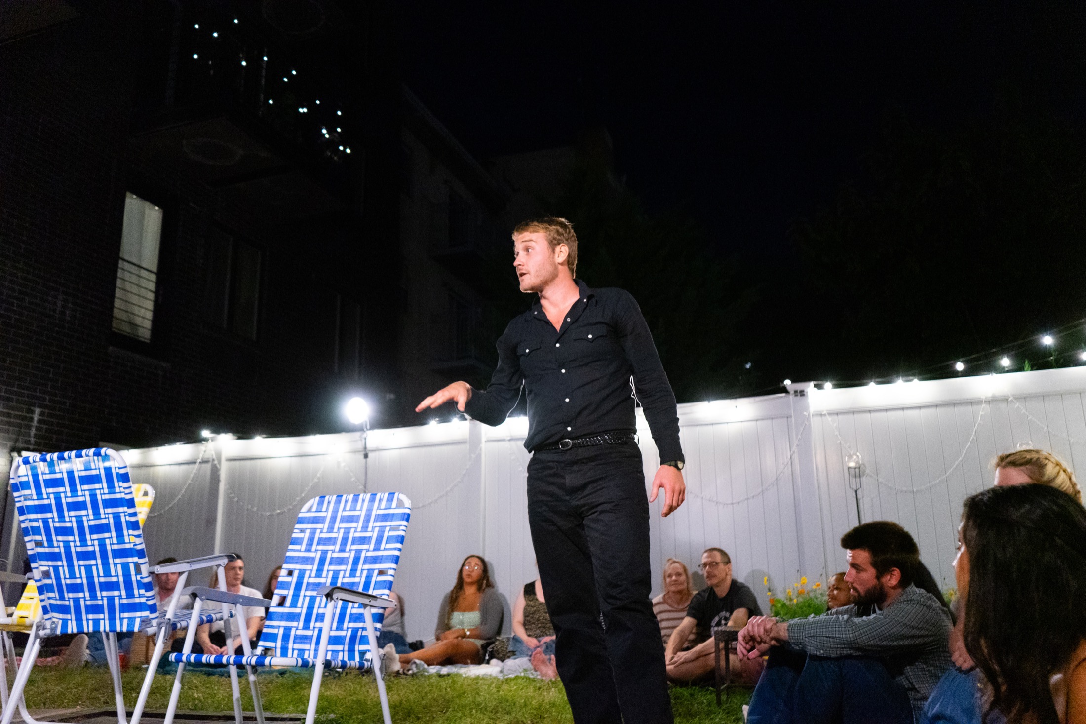 The Stage Manager addresses the audience at night in a backyard