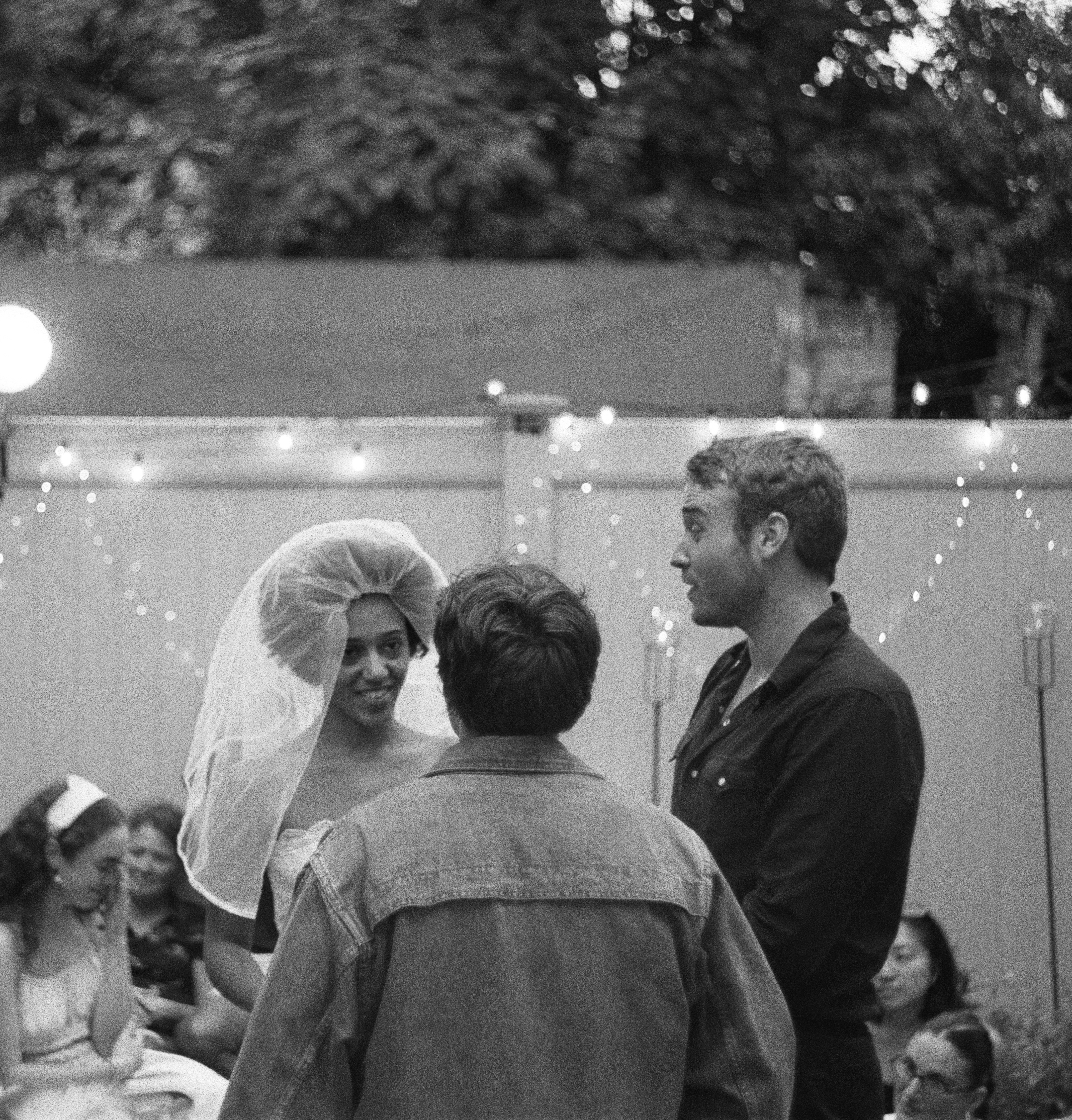 A black-and-white Our Town wedding scene with Emily Webb, George Gibbs, and the Stage Manager