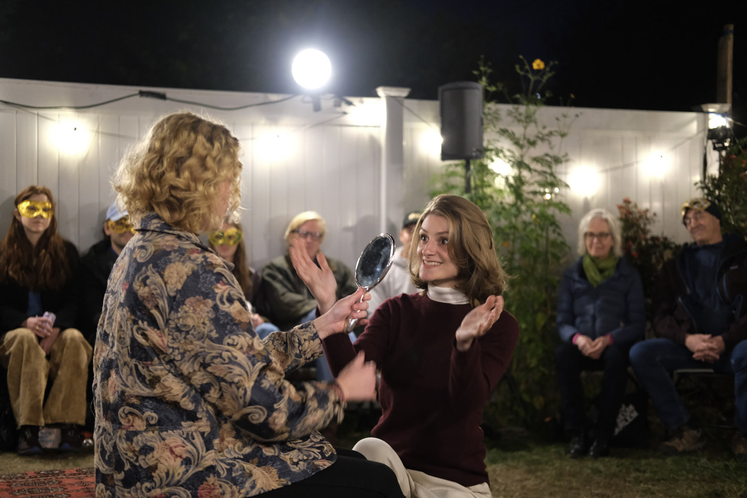 Two performers play a mirror scene while audience members watch