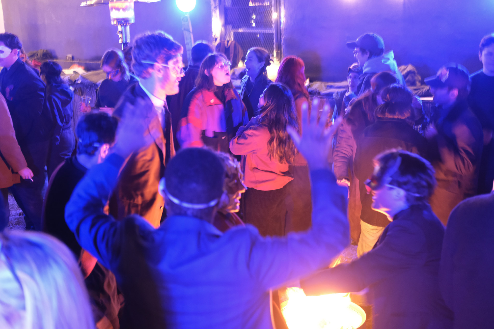 Audience and performers gathered in saturated blue and red light at Romeo and Juliet