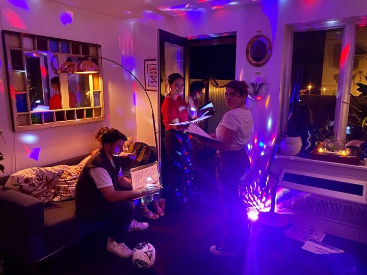 Performers read inside under colorful party lights
