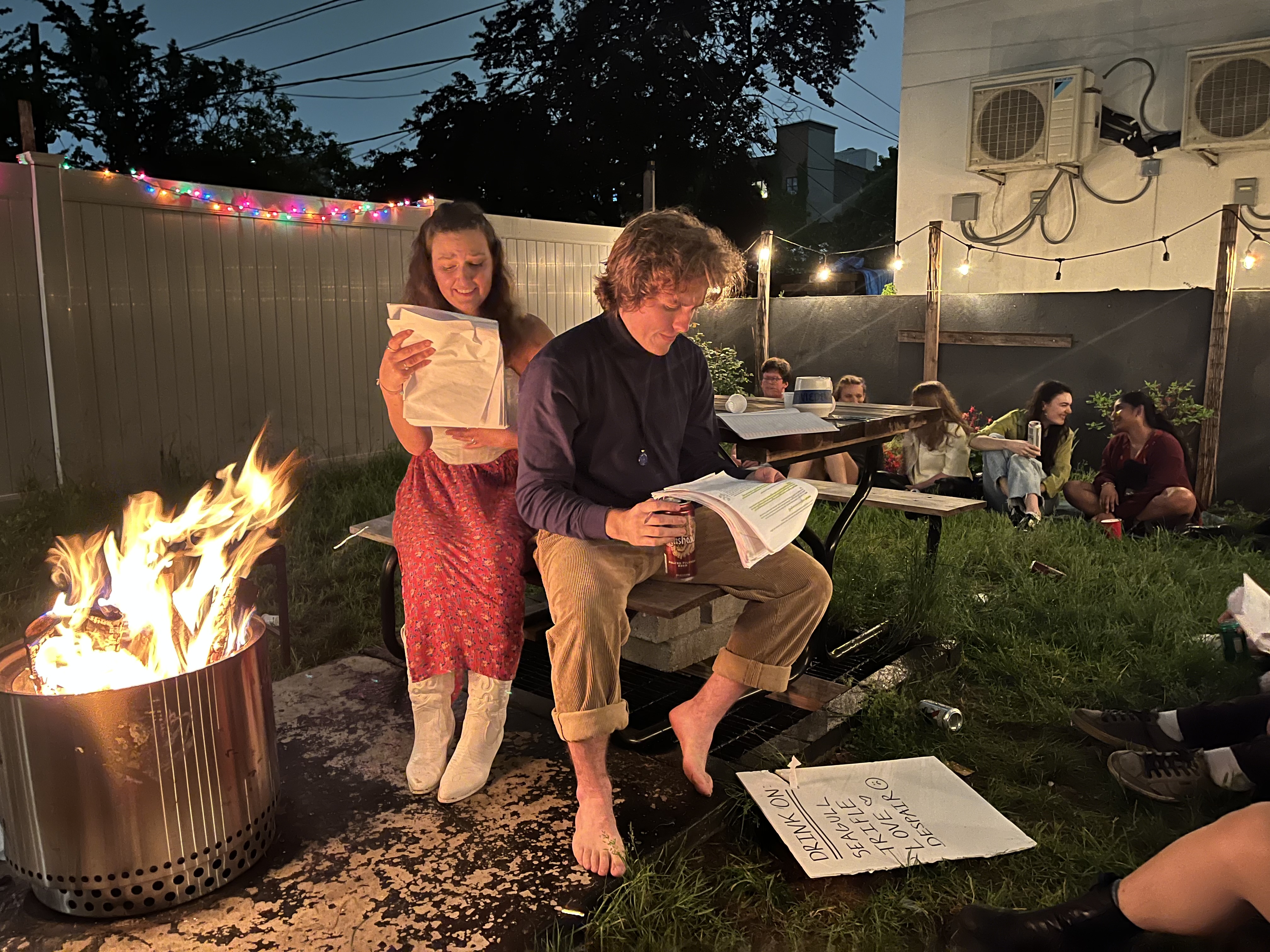 Fiona Selmi and John Murphy read beside a backyard fire during The Seagull