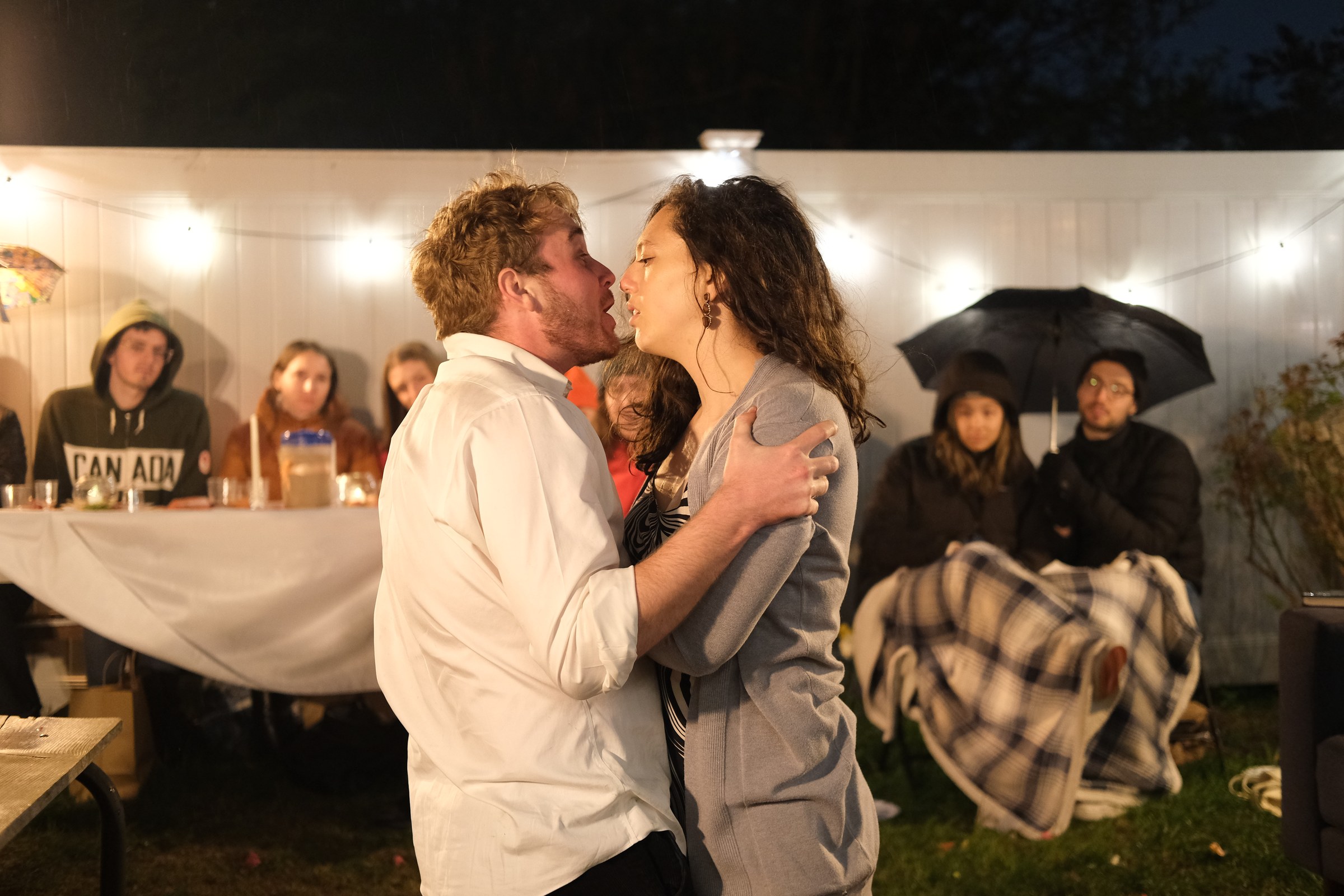 Martha and George hold one another while audience members watch