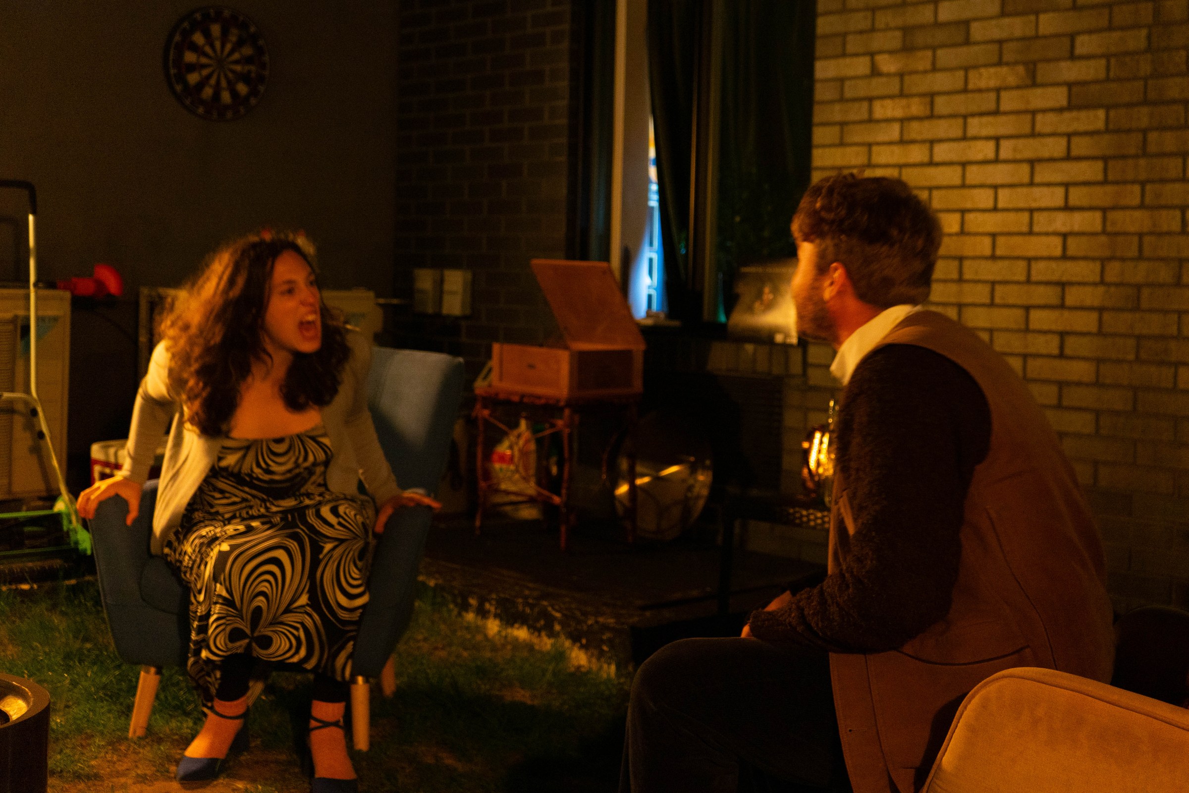 Martha sits facing George and Nick in a warm-lit backyard